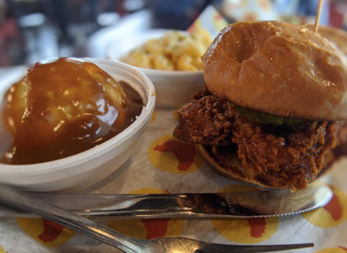 A crispy fried chicken sandwich with pickles, served with a side of macaroni and cheese and a dessert of apple pie.