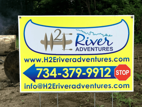 Sign for H2E River Adventures featuring contact info and website, with a blue and yellow design.