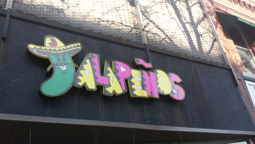 Colorful sign for "Jalapeños" featuring a cartoon pepper wearing a sombrero.