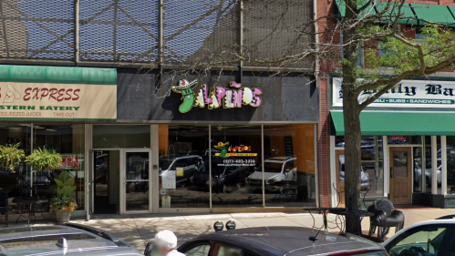A storefront with the sign "Javino's" above large glass windows, surrounded by other businesses on a city street.