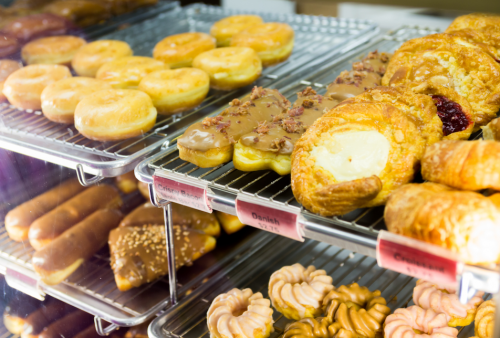 A display case filled with various donuts and pastries, including glazed, chocolate, and fruit-filled options.