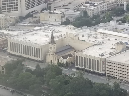Aerial view of a city block featuring a church and surrounding buildings.