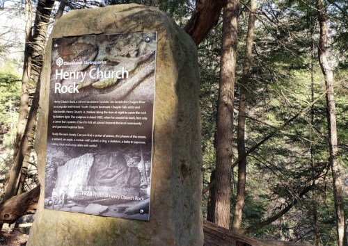 Sign on a rock titled "Henry Church Rock," describing its history and significance in a forested area.