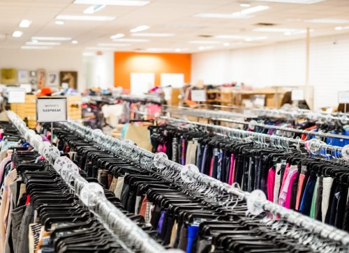 A clothing store interior with racks of women's sleepwear and various apparel in a bright, spacious environment.