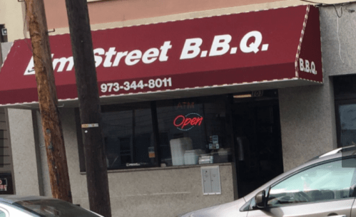 A storefront with a red awning reading "Elm Street B.B.Q." and an "Open" sign in the window.