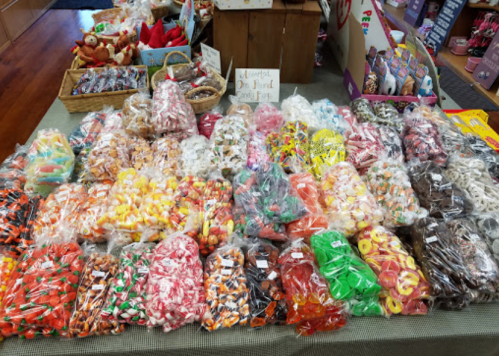 A colorful display of assorted candies in clear bags, arranged neatly on a table in a shop.