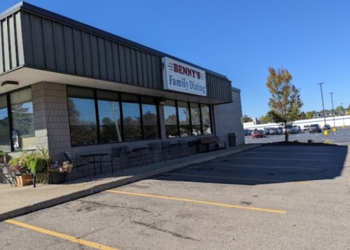 Exterior of Benny's Family Dining, featuring large windows and a parking lot under a clear blue sky.