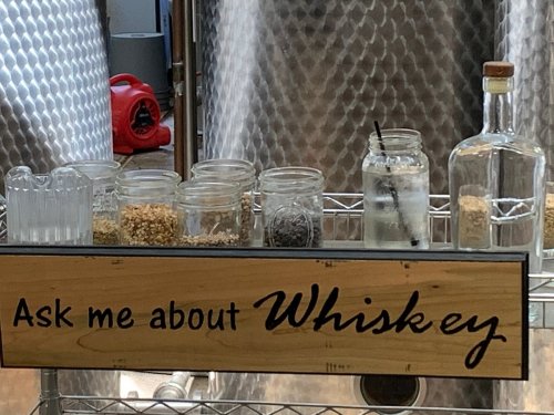 A display with jars of ingredients and a sign that says "Ask me about Whiskey."