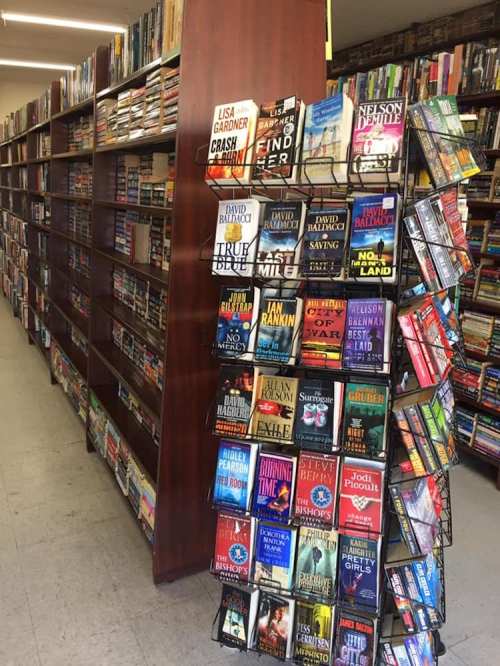 A bookstore interior featuring shelves of books and a display rack with various titles.