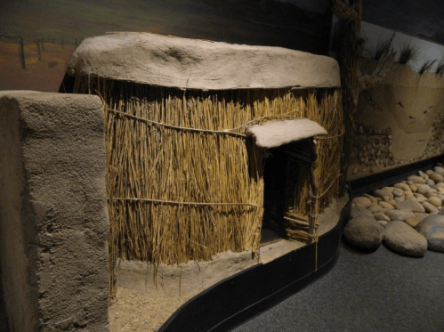 Model of a traditional straw and mud hut, showcasing natural materials and simple construction.