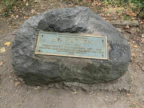 Plaque on a rock honoring M.L. Hutton, superintendent and director, 1883-1941, with historical details.