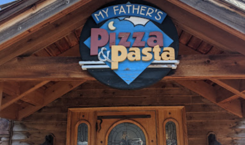 Sign for "My Father's Pizza & Pasta" on a wooden building entrance.
