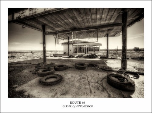 Abandoned gas station on Route 66 in Glenrio, New Mexico, surrounded by old tires and a desolate landscape.