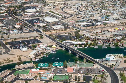 Aerial view of a bridge over a river, surrounded by residential areas, parking lots, and commercial buildings.