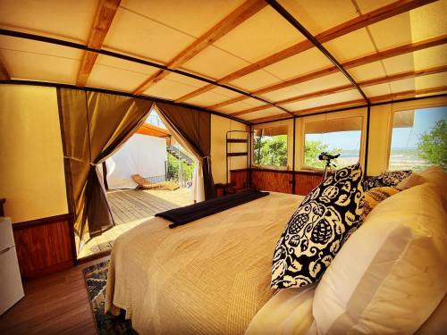 Cozy bedroom with a large bed, wooden accents, and open curtains leading to a deck with a view.