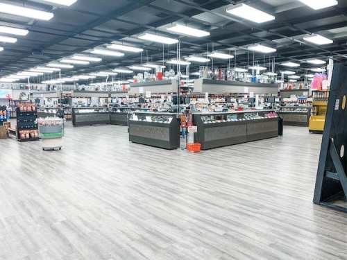 A spacious retail store interior with display shelves, counters, and bright overhead lighting.