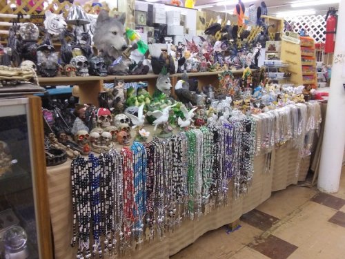 A cluttered display of various decorative items, including skulls, figurines, and colorful beaded necklaces.