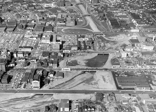 Aerial view of a city with labeled streets, parking lots, and construction areas, showcasing urban development.