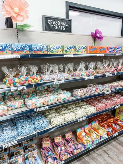 A colorful display of seasonal treats, featuring various candies and snacks arranged on shelves.