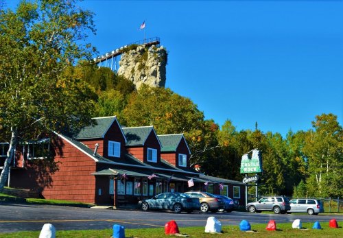A red building with a sign reading "Castle Rock" in front of a rocky cliff and clear blue sky.