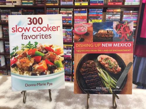 Two cookbooks displayed on stands: "300 Slow Cooker Favorites" and "Dishing Up New Mexico," featuring colorful food images.