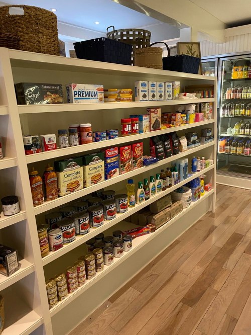 A neatly organized shelf displaying various food items, cleaning supplies, and household products in a store.