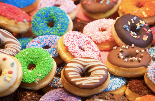 A colorful assortment of donuts with various toppings, including sprinkles, chocolate, and vibrant icing.