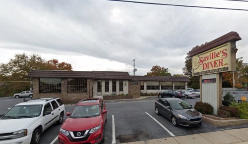 Exterior view of Saville's Diner with parked cars in front and a cloudy sky overhead. Sign reads "Open."