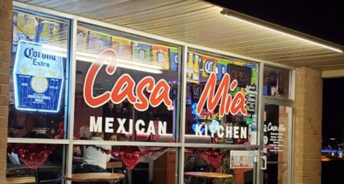 Exterior view of Casa Mia Mexican Kitchen, featuring colorful signage and festive decorations in the windows.