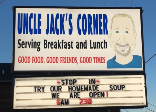 Sign for Uncle Jack's Corner, promoting breakfast and lunch with a friendly message about homemade soup and open hours.