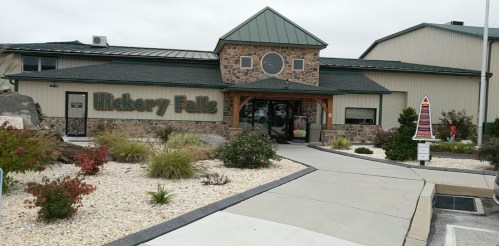 Exterior view of Hickory Falls building with stone facade, green roof, and landscaped entrance.