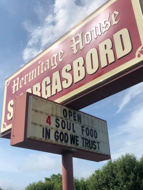 Sign for Hermitage House, advertising "Open 4 Soul Food" with "In God We Trust" displayed below.