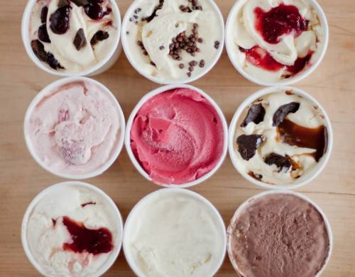Nine cups of ice cream in various flavors, arranged in a 3x3 grid, featuring swirls and toppings.