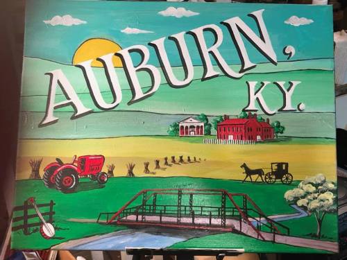 Colorful sign featuring "AUBURN, KY" with a tractor, horse-drawn carriage, and scenic countryside elements.