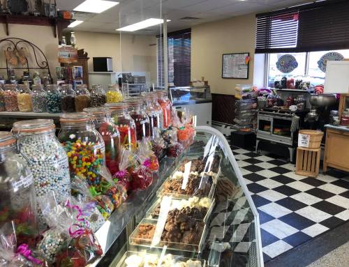 A colorful candy shop display with jars of sweets and treats, featuring a checkered floor and a cozy atmosphere.