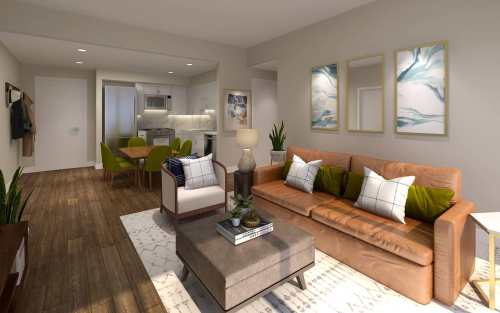 Cozy living room with a brown sofa, green chairs, and modern decor, leading to a kitchen and dining area.