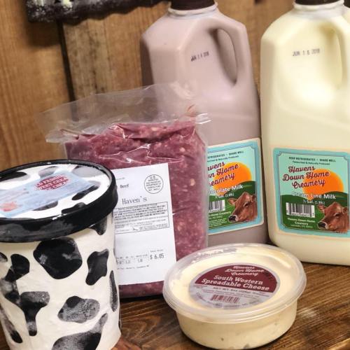 A selection of dairy products and ground beef, including chocolate milk, cream line milk, and spreadable cheese.