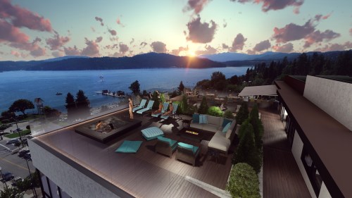 A rooftop terrace with lounge chairs and a fire pit, overlooking a lake at sunset with mountains in the background.