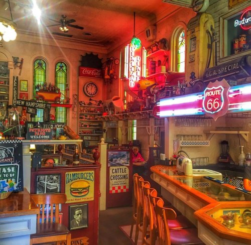 A vibrant diner interior filled with vintage signs, neon lights, and retro decor, creating a nostalgic atmosphere.