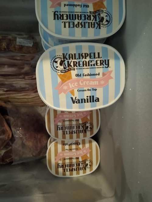 Containers of Kalispell Kreamery vanilla ice cream stacked in a freezer, labeled "Old Fashioned Ice Cream."