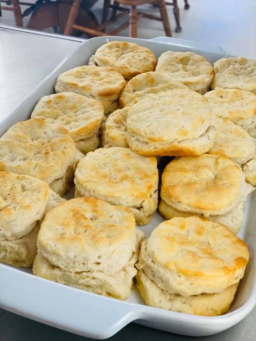 A tray of freshly baked, golden-brown biscuits stacked neatly.