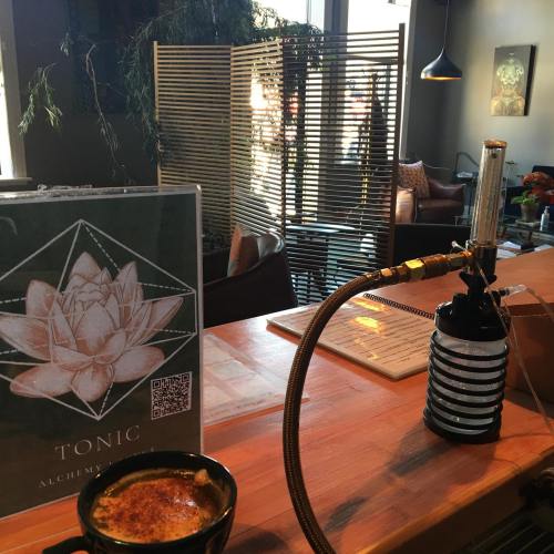 A cozy café interior featuring a wooden counter, a drink, and a decorative screen in the background.