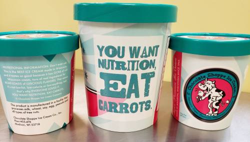 Three ice cream containers with playful labels promoting carrots as a nutritious choice. Bright colors and fun designs.