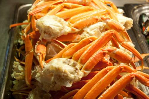 A large pile of cooked crab legs, showcasing their bright orange color and tender meat.