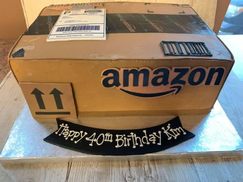 A cake designed to look like an Amazon package, with "Happy 40th Birthday Kim" written on a black banner.