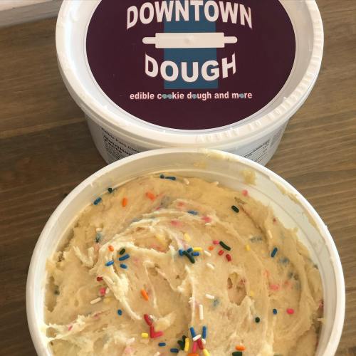 A tub of edible cookie dough with colorful sprinkles, labeled "Downtown Dough."