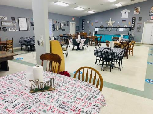 A cozy dining area with tables set for guests, featuring festive decor and a welcoming atmosphere.