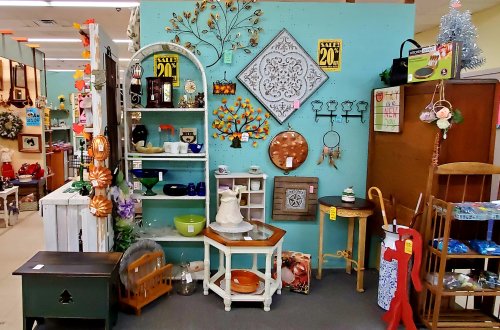 A colorful display of vintage decor and furniture items, including shelves, wall art, and various collectibles.