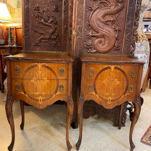 Two ornate wooden nightstands with intricate inlay designs, set against a carved wooden screen featuring a dragon.