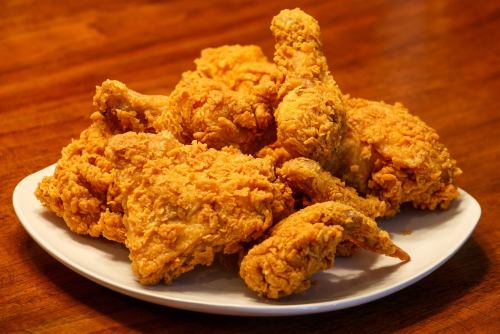 A plate of crispy, golden-brown fried chicken pieces arranged neatly.